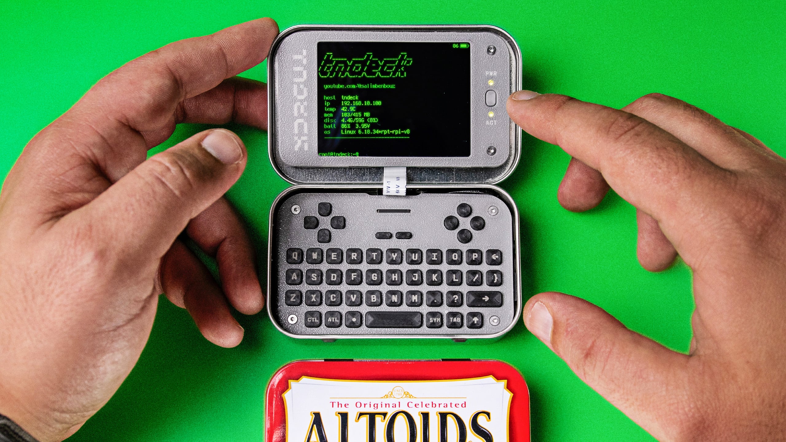 Photo of the TN Deck, a hand-built cyberdeck housed in an open Altoids-style tin with an integrated keyboard and small screen, from Salim Benbouziyane's project page.