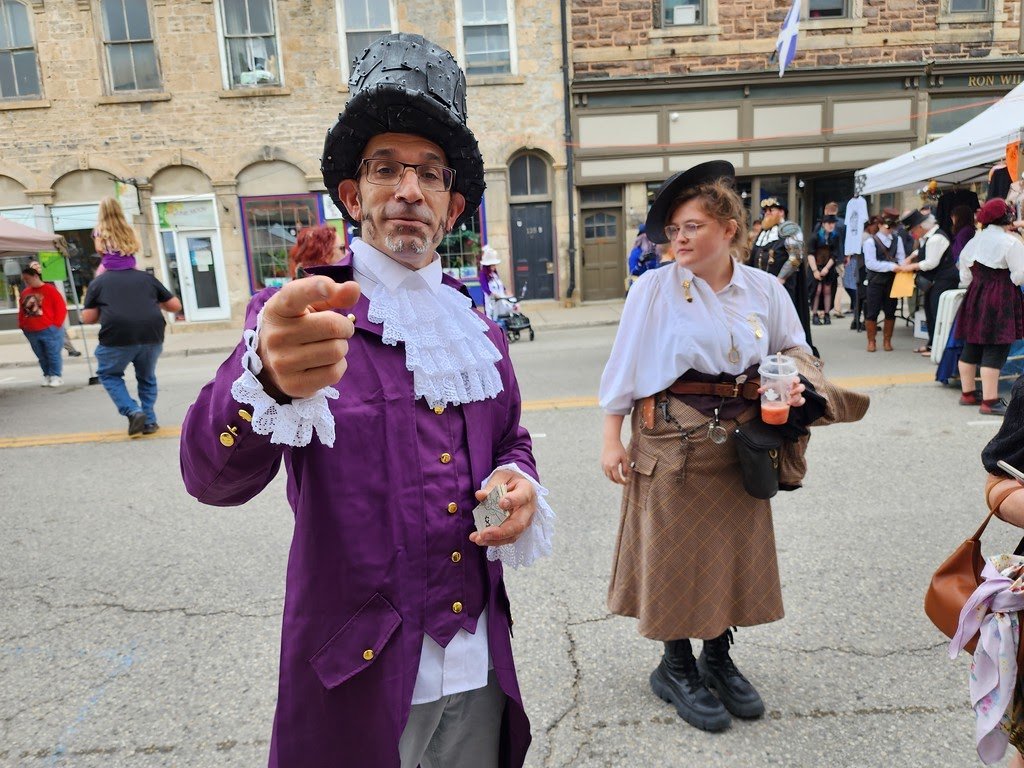 Cogs and Clockwork Fergus Steampunk Festival street scene with costumed attendees in Victorian steampunk attire